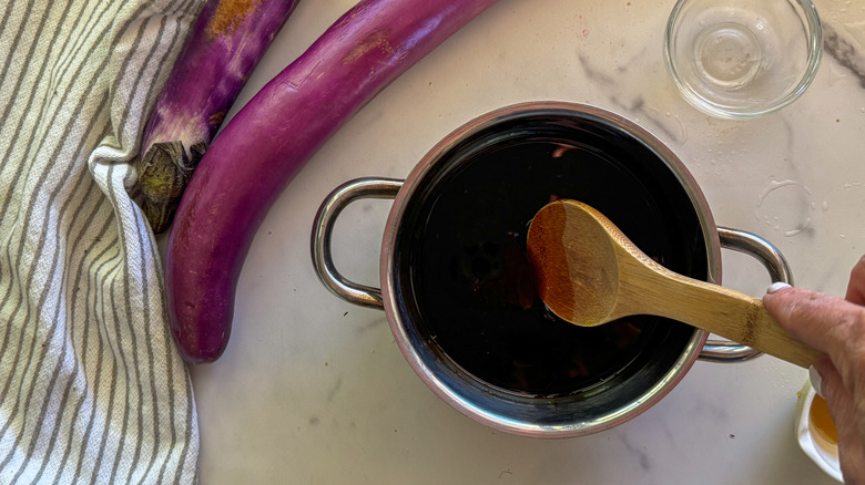 hand stirring sauce in pot