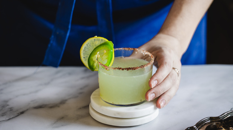 hand serving spicy margarita