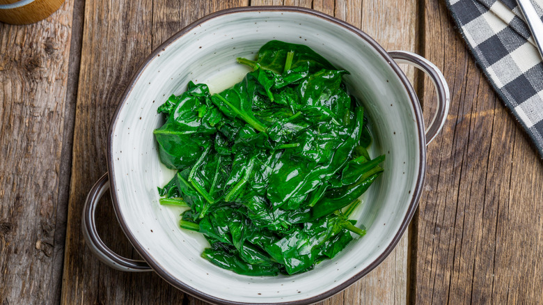 Steamed spinach wooden table