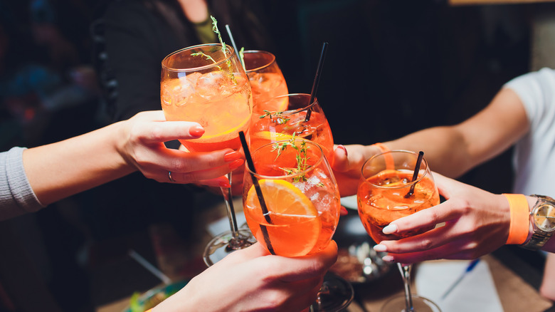 People cheers aperol spritz drinks