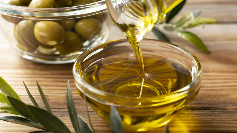 pouring olive oil into a glass bowl