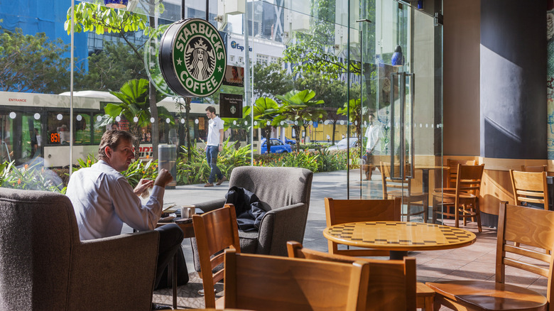 A customer sits at a table inside of a Starbucks