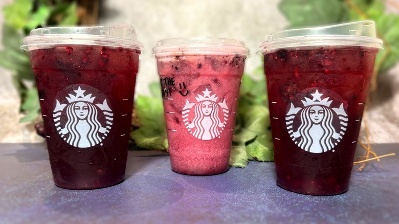 Three Starbucks drinks in branded plastic cups.