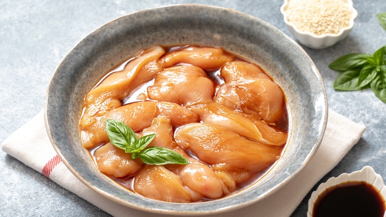 marinating raw chicken in ceramic bowl