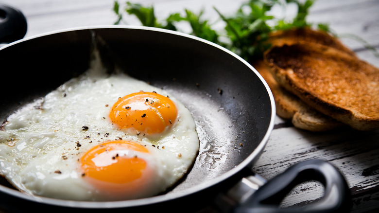 eggs frying in pan, toast