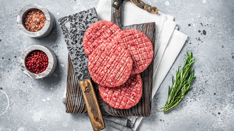 Burger patties on cutting board