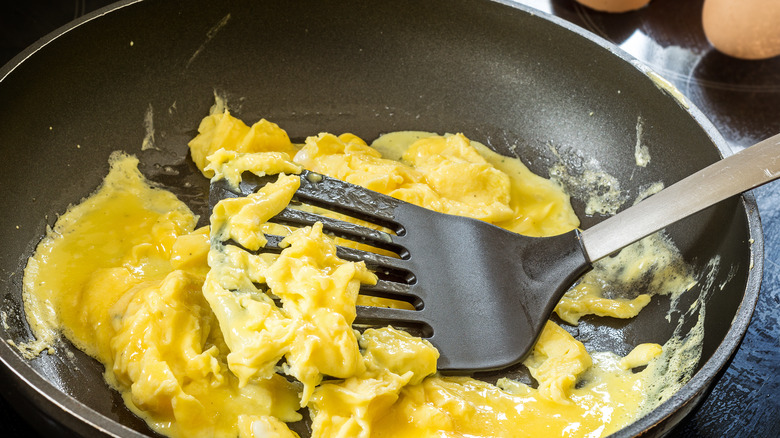 stirring scrambled eggs with plastic spatula