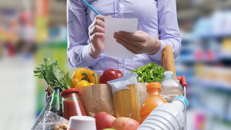 woman at grocery store with shopping list