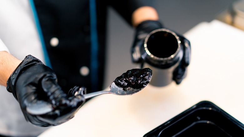 Scooping cuttlefish ink from a jar