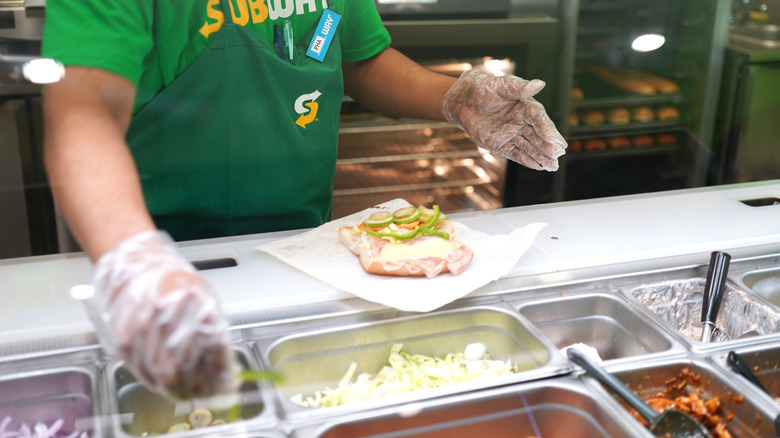 Subway employee preparing a sandwich