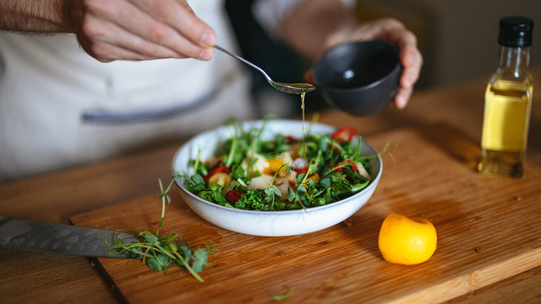 Adding olive oil to a salad