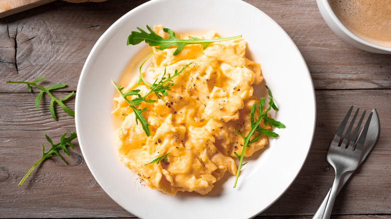 Plate of scrambled eggs on a rustic wood table