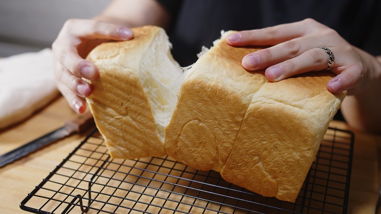 tearing apart fluffy bread loaf