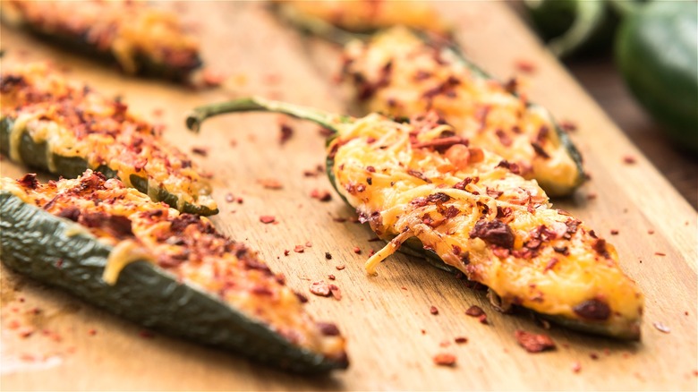 Cooked jalapenos with cheese and pepper close up