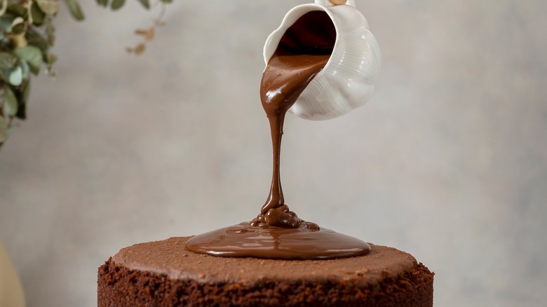 Pouring chocolate glaze on cake