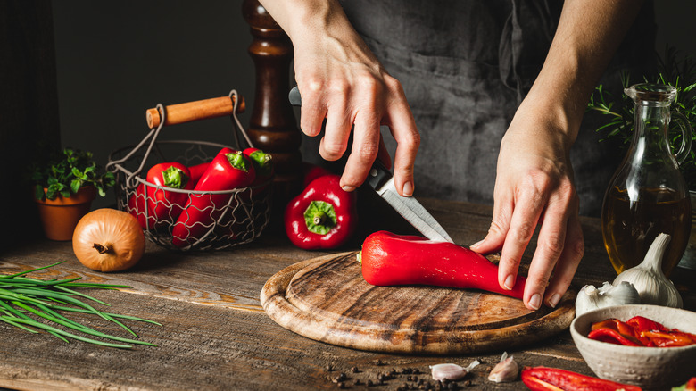 chef slicing red bell peppers