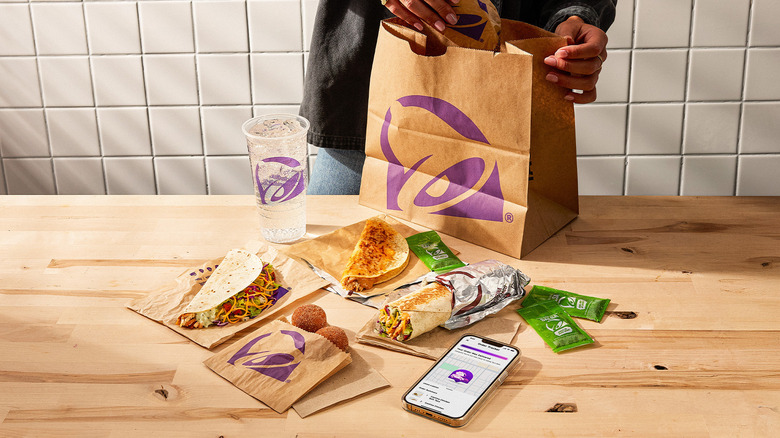 Person removing Taco Bell foods from a paper bag