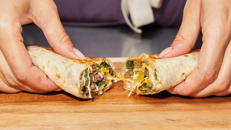 Hands holding the rolled poblano quesadilla