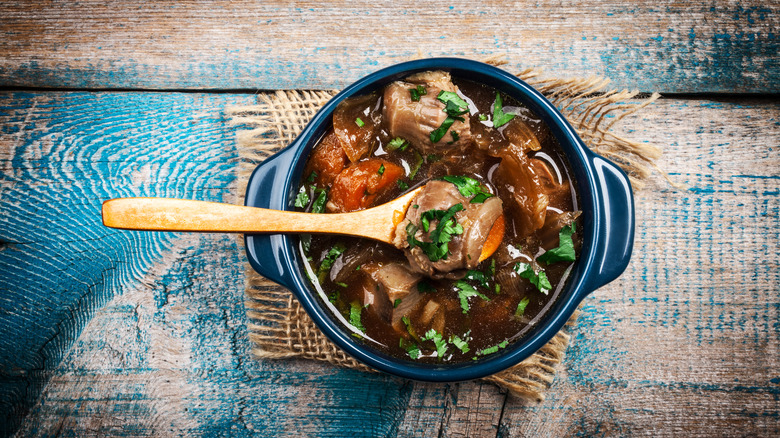 hearty soup on wood table with spoon