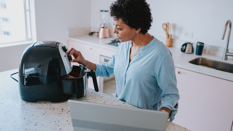 ﻿﻿woman using air fryer