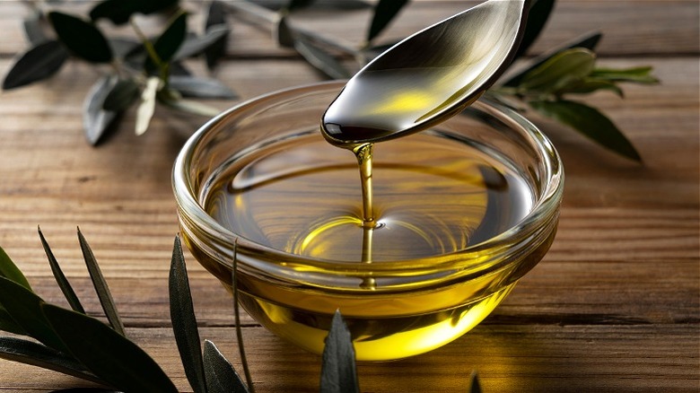 Spooned olive oil in clear bowl