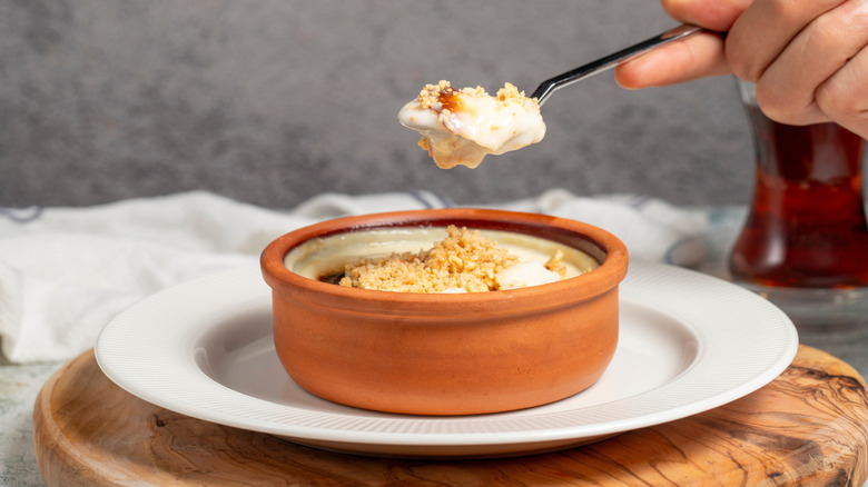 a spoonful of creamy rice pudding in terracotta pot