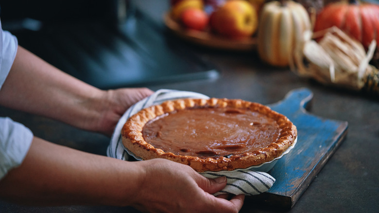 Person holding pumpkin pie