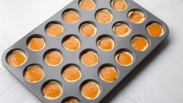 Unbaked tart shells with pumpkin pie filling