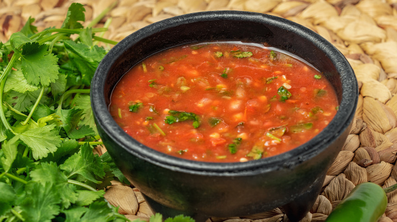 A bowl of salsa and cilantro