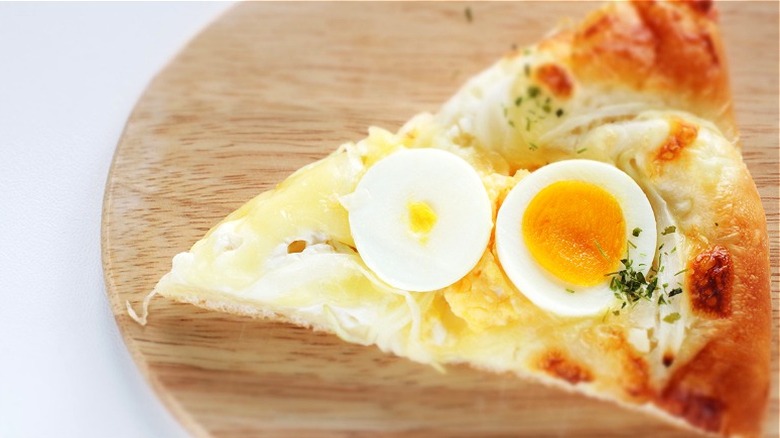 Sliced hard-boiled egg on pizza