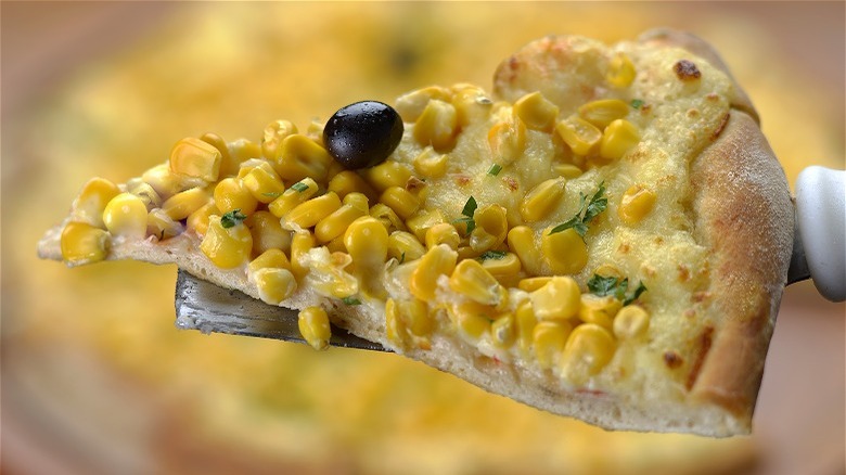 Slice of pizza with corn topping