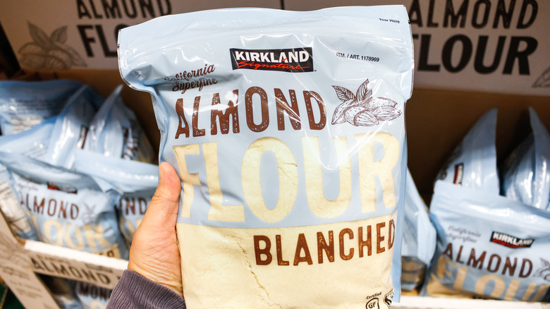 man holding a bag of kirkland almond flour