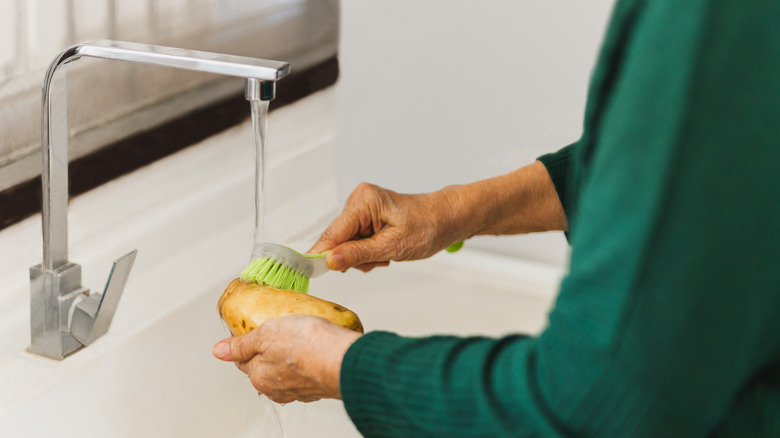 Scrubbing potatoes with brush