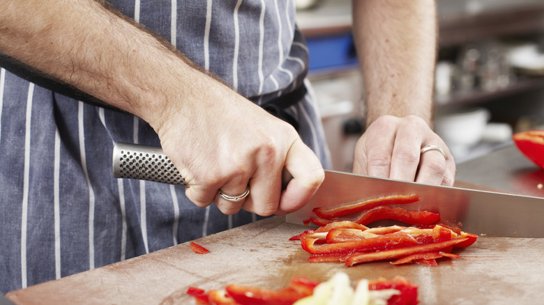 man cutting pepper with knife