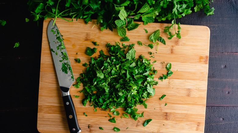 cut parsley on wood cutting board