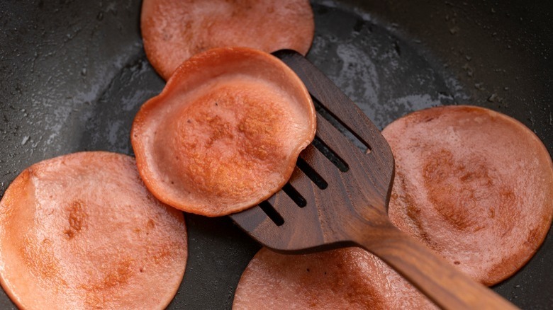 Frying bologna in pan with spatula