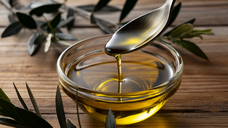 Olive oil falling off a spoon