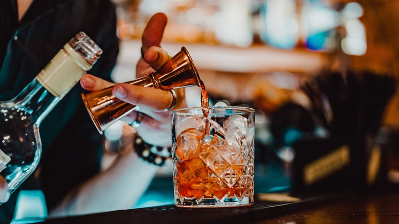 bartender pouring negroni