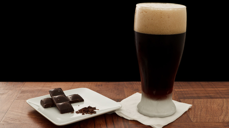 glass of stout beer and pieces of chocolate