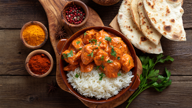 dish of chicken tikka masala with naan and spices