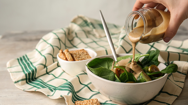 Pouring tahini over salad