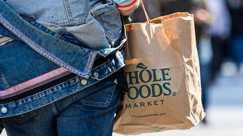 Woman carrying whole foods bag