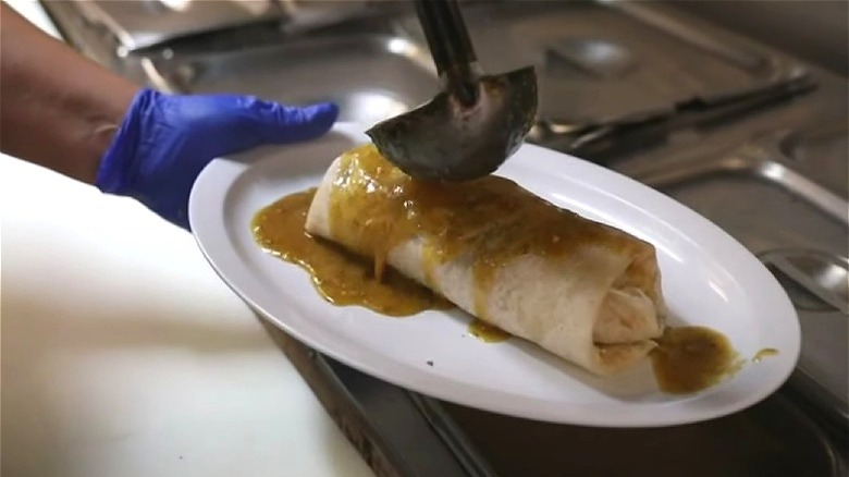 Burrito being covered with sauce