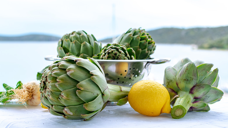 colander with artichokes and lemon