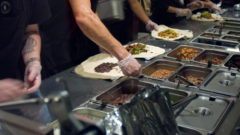 Workers preparing Chipotle burritos