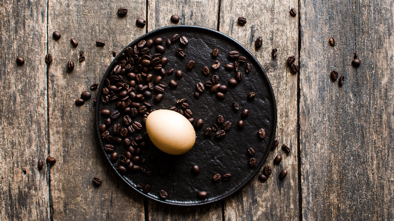 Egg and coffee beans on plate 