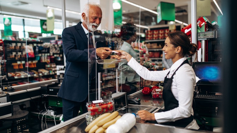 Cashier checking out customer at grocery store