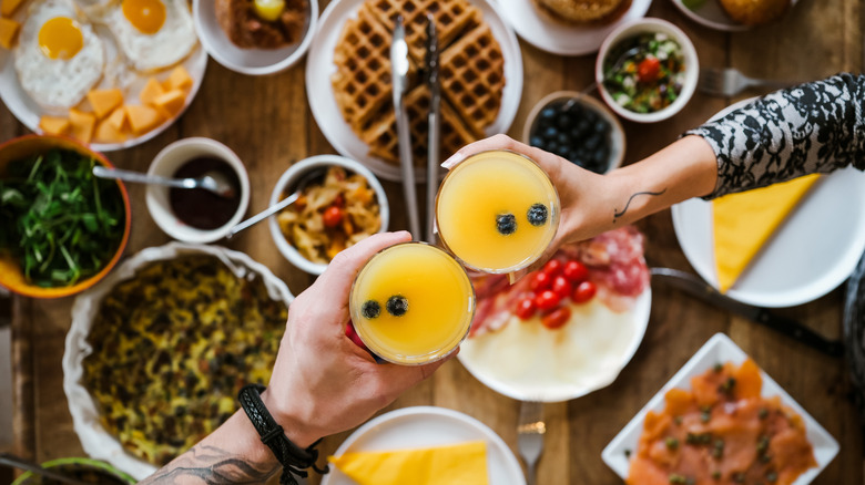 Brunch spread with friends toasting