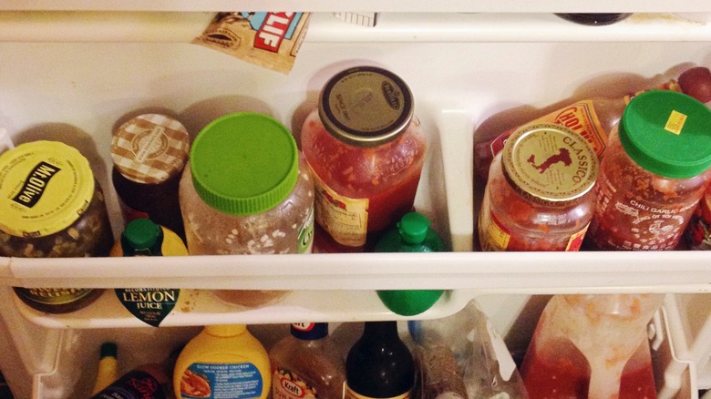 cluttered refrigerator door shelves