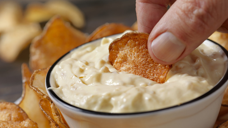 dipping a chip into french onion dip